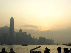 Die Skyline von Hongkong vor dem Hintergrund des Victoria Peak bei Abenddämmerung.